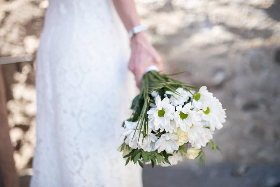 Pengantin memegang buket bunga aster putih